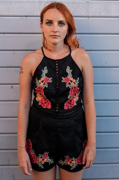 A close-up shot of a woman wearing a halter top with intricate detailing. She is wearing delicate, dangling earrings that draw attention to her face without clashing with the neckline.