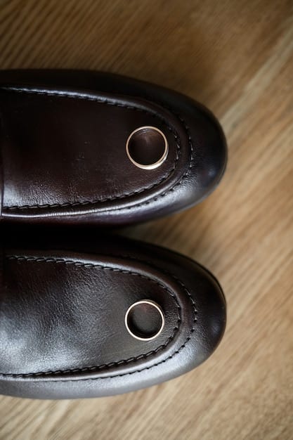 A close-up shot of a pair of meticulously polished, dark brown leather Oxford shoes placed on a clean wooden surface. The focus is on the shine and the quality of the leather, highlighting the importance of well-maintained footwear.