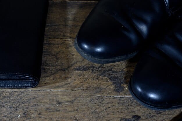 A polished pair of black leather Oxford shoes on a wooden surface. The shoes are reflecting light and look brand new.
