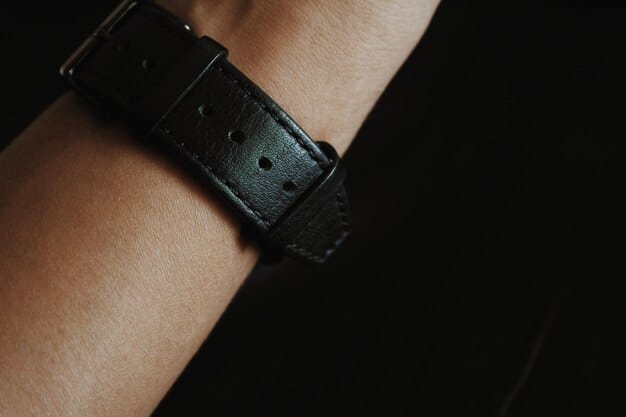 Close-up of a luxury watch with a leather strap on a man's wrist, capturing the details of the watch face and the texture of the strap. The background is blurred, focusing on the watch itself.
