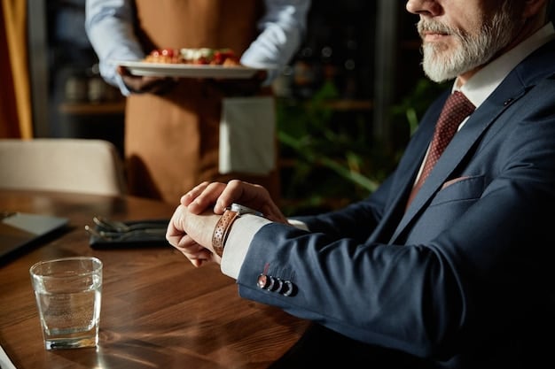 A man in a suit adjusting his classic silver watch, with a blurred background showing a fancy restaurant in Spain. The focus is on the interaction with the watch and the overall elegant atmosphere.