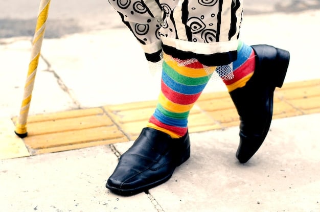 A man wearing stylish dress socks with a colorful geometric pattern, paired with leather loafers and dress pants. The focus is on the exposed part of the socks between the shoe and the pant hem.