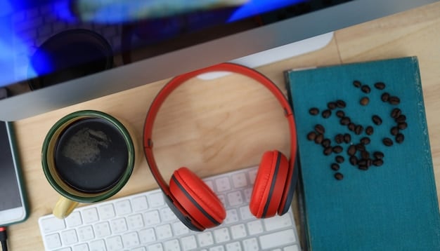 A close-up of noise-cancelling headphones on a desk next to a laptop, with a blurred background of a home office setting.