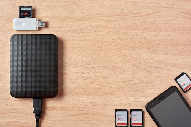 An overhead shot of a sleek, black power bank with multiple USB ports, lying on a wooden table next to a smartphone and a charging cable. The power bank is partially covered by sunlight, highlighting its compact and modern design.