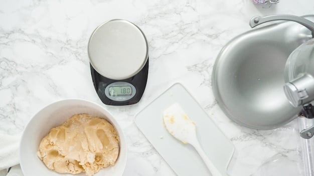 A close-up of a digital kitchen scale displaying precise measurements of ingredients. The scale is sleek and modern, with a clear LCD screen showing the weight in grams. The background features a blurred kitchen scene with various cooking utensils